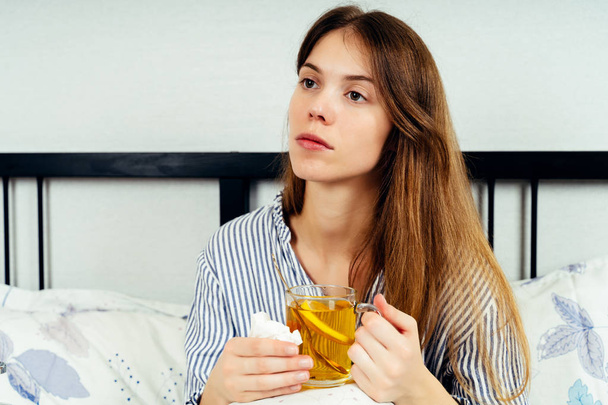 Jovem mulher sentada na cama com muitos remédios na mesa da cama
 - Foto, Imagem