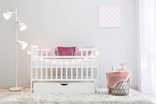 Interior of light modern baby room with crib - Foto, imagen