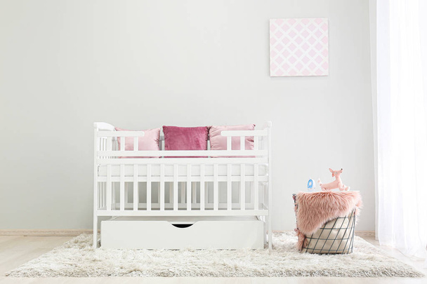 Interior of light modern baby room with crib - Foto, imagen