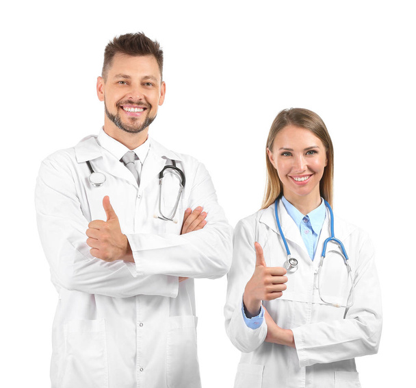 Mężczyzna i kobieta lekarze wykazujący kciuk w górę na białym tle - Zdjęcie, obraz