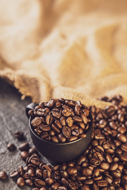 Coffee beans. Coffee cup full of coffee beans. Toned image - Fotó, kép