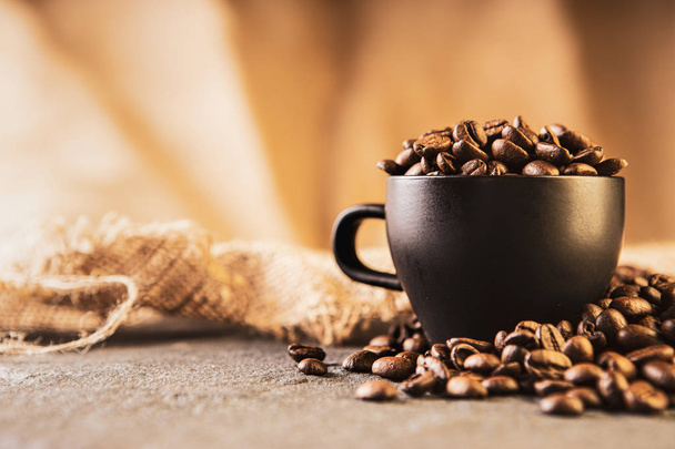 Coffee beans. Coffee cup full of coffee beans. Toned image - Фото, зображення