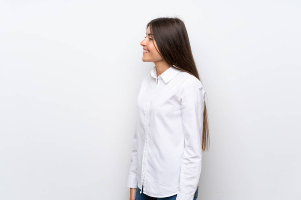 Молода жінка над ізольованим білим тлом дивиться в бік
 - Фото, зображення