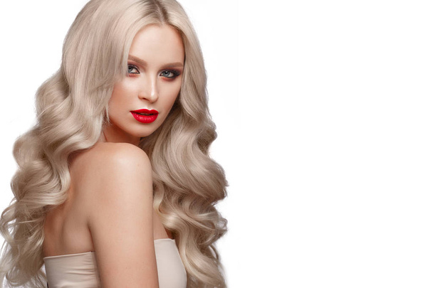 Beautiful blonde in a Hollywood manner with curls, natural makeup and red lips. Beauty face and hair. - Fotó, kép