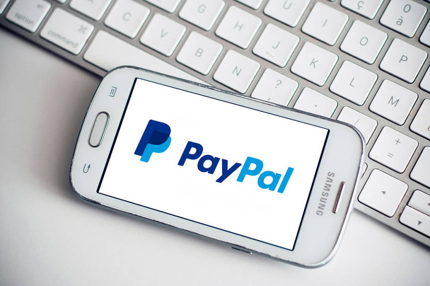 Paypal logo on smartphone screen from Samsung brand on white keyboard background - Foto, Imagem