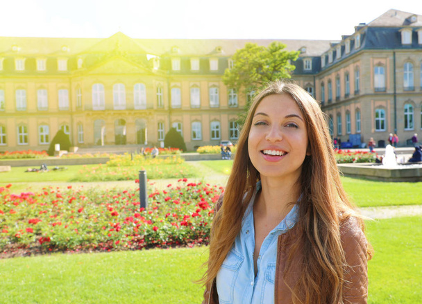 Smiling cheerful young woman in front of Neues Schloss (New Palace) of Stuttgart, Germany. - Photo, Image