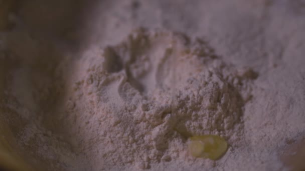 Flour on a flat surface. Raw egg flows into the flour. Close-up video - Video, Çekim