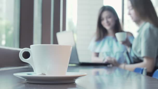 Csésze kávé az asztalon két diák dolgozik a projekt a háttérben - Felvétel, videó