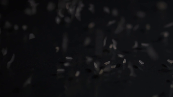 A rizsszemcse sötét felszínre hullik. Rizsszemes közelkép. Fekete háttér. - Felvétel, videó