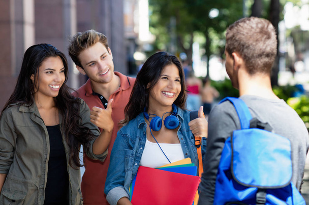 Group of talking german and latin american students - 写真・画像
