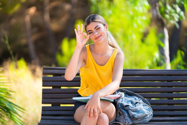 Teenager student girl at outdoors showing ok sign with fingers - Photo, Image