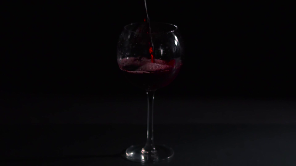 Červené víno nalévá do vína, tmavé pozadí, studio video shot - Záběry, video