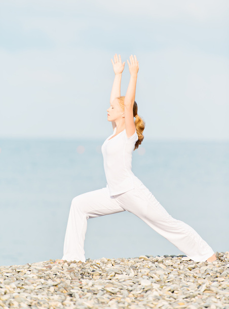 Femme en blanc faisant du yoga sur la plage
 - Photo, image