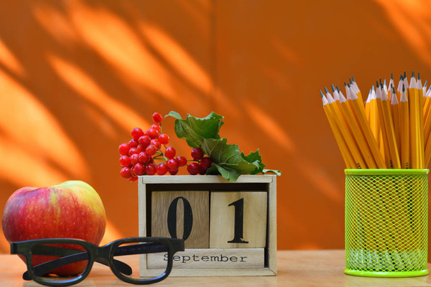 шкільне обладнання олівці книги скляний стіл. назад до концепції школи. 1 вересня текст на дерев'яному календарі блоків
 - Фото, зображення