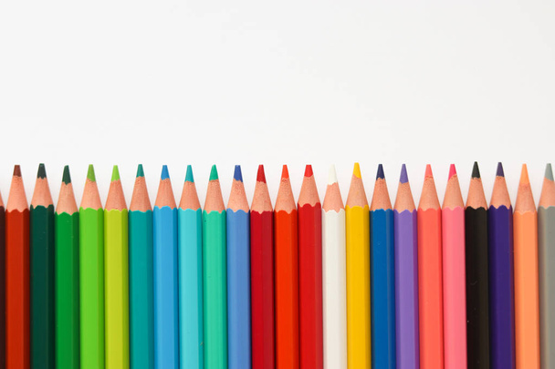 line of colored pencils on a light background. Close-up - 写真・画像