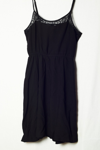 Черное платье на вешалке на белом фоне
 - Фото, изображение