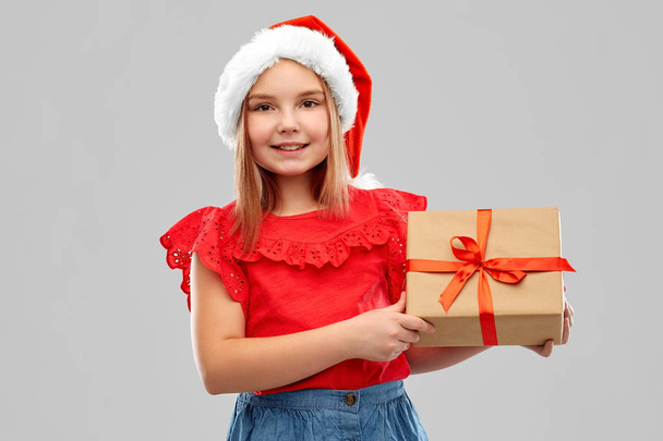 smiling girl in snata hat with christmas gift - Photo, image