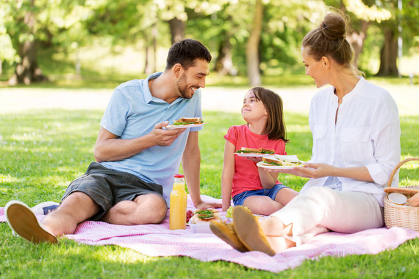 happy family having picnic at summer park - Foto, Imagem