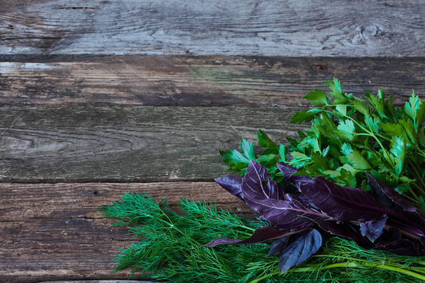 Bunches de endro fresco, salsa e manjericão vermelho em uma superfície de madeira áspera velha, conceito de alimentação saudável, foco seletivo
 - Foto, Imagem