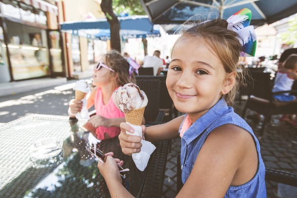 アイスクリームを食べるかわいい2人の女の子の肖像画 - 写真・画像