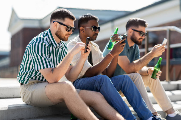 men with smartphones drinking beer on street - 写真・画像