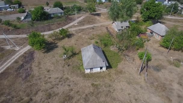 Una vieja casa de un piso en una vista aérea del pueblo ucraniano. El dron vuela alrededor de una casa unifamiliar en el pueblo. Cerca del bosque de pinos
. - Metraje, vídeo