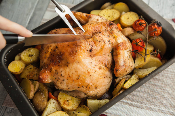 Процесс нарезки готового блюда, жареного, хрустящего цыпленка на порции для праздника Дня благодарения
. - Фото, изображение