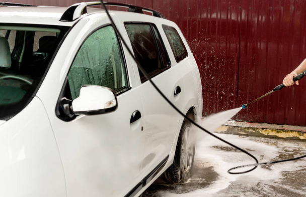 The process of washing a white car using a pressure washer - Photo, Image