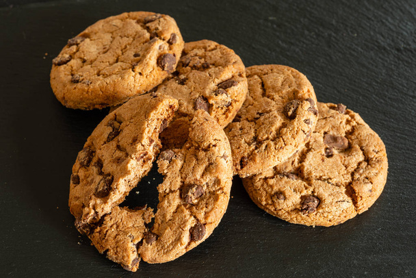 Biscuits aux pépites de chocolat sur plateau noir
. - Photo, image