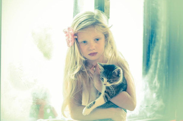 girl with long blond hair holding little cat - Photo, Image