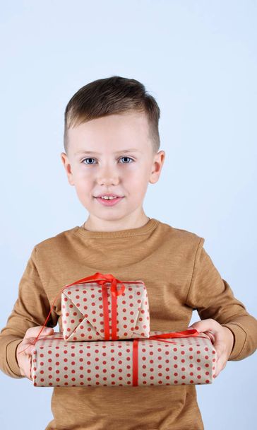 Child holding Christmas gift box in hand. Isolated on white background - Foto, Bild