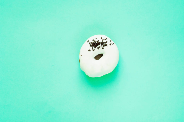 Glazed donut  with black chocolate sweet on mint color backgroun - Foto, immagini