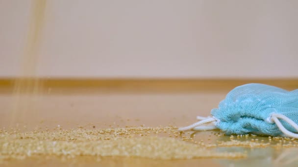 Białe nasiona quinoa w przezroczystym niebieskim worek wielokrotnego użytku na drewnianym tle. Koncepcja wegetariańskiej żywności - Materiał filmowy, wideo