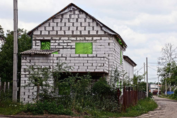 λευκό τούβλο ημιτελές σπίτι σε ένα εργοτάξιο σε πράσινη βλάστηση - Φωτογραφία, εικόνα