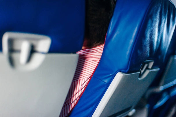Интерьер самолета с пассажирами на сиденьях и стюардессой, идущей к алтарю. - Фото, изображение