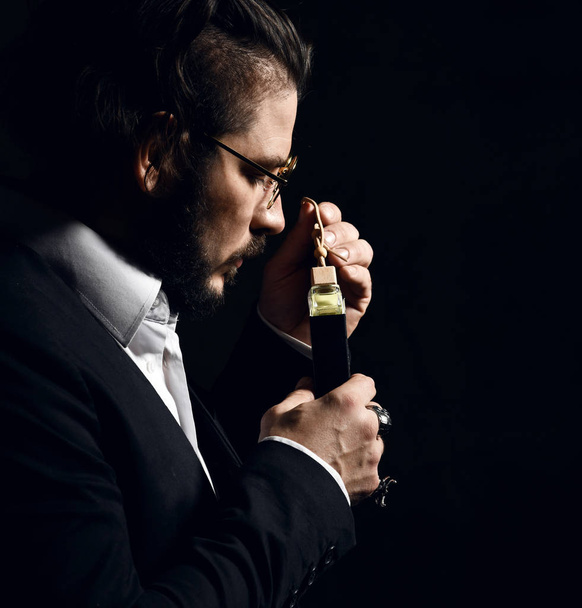 Brutal man with beard and modern hairstyle smell auto perfume wear business classic suit - Foto, immagini
