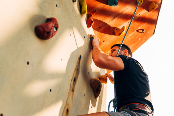młody sportowe człowiek wspinaczka na praktyce zamontować ściany zewnątrz - Zdjęcie, obraz