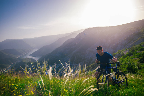 Perspektive eines fitten Mountainbikers, der sein Fahrrad bergauf schiebt - Foto, Bild