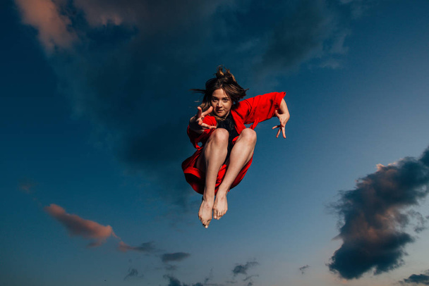 Glück, Freiheit, Bewegung und Menschen-Konzept - lächelnde junge Frau springt in die Luft - Foto, Bild