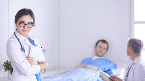 Lekarz, sprawdzenie rytmu serca pacjenta w łóżku z stetoskop - Zdjęcie, obraz
