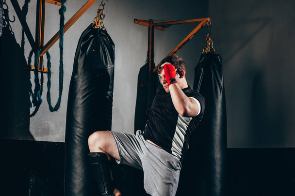 Kickbox musclé combattant exercice avec sac de boxe à la salle de gym
 - Photo, image
