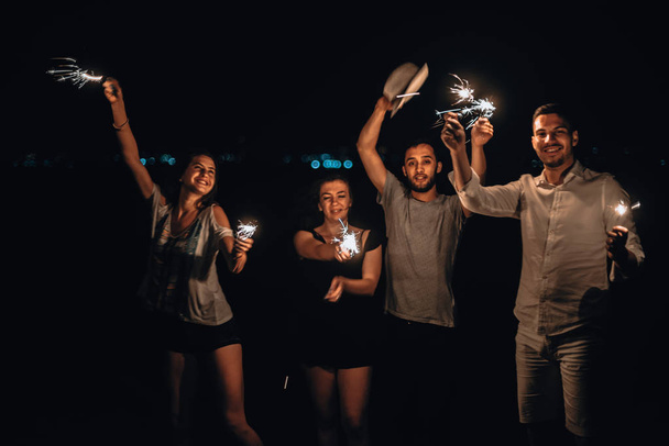Happy friends lighting sparklers and enjoying freedom - Foto, Imagem