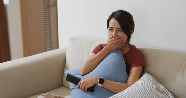 Жінка відчуває себе нудно під час перегляду по телевізору вдома
 - Фото, зображення