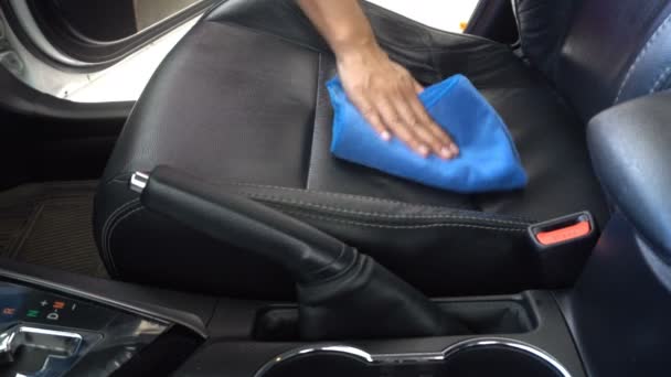Mujer limpiando a mano el interior del coche con cera y tela de microfibra azul
 - Imágenes, Vídeo