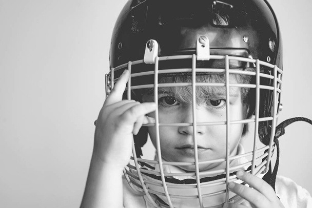 Hockey or rugby helmet. Sport childhood. Future sport star. Sport upbringing and career. Boy cute child wear hockey helmet close up. Safety and protection. Protective grid on face. Sport equipment - Fotografie, Obrázek