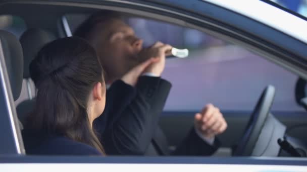 Dziewczyna stara się powstrzymać człowieka picia alkoholu na siedzeniu kierowcy, szkodliwe uzależnienie - Materiał filmowy, wideo