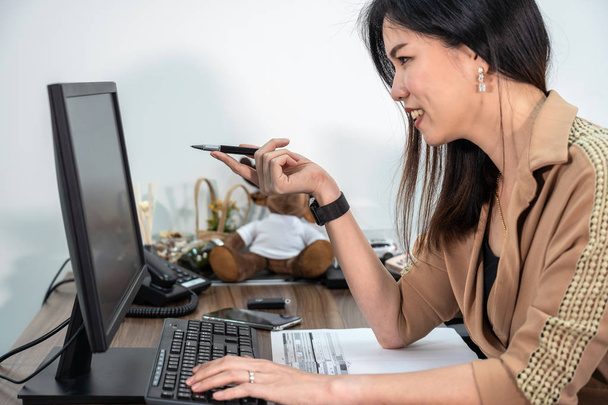 Imprenditrice asiatica in abito formale che utilizza e punta la penna sullo schermo del computer in ufficio, business e piano di progetto per il concetto di servizio clienti
 - Foto, immagini