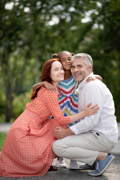 Άνθρωπος και γυναίκα αισθάνονται ευτυχισμένοι μετά την υιοθέτηση του χαριτωμένο κορίτσι - Φωτογραφία, εικόνα