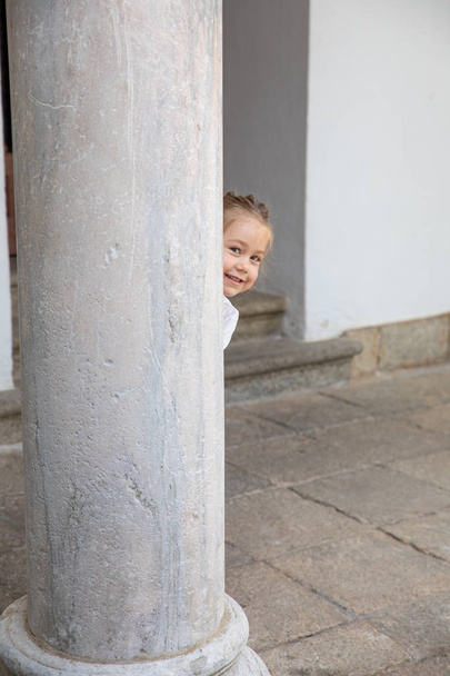 litlle bambino sbirciare dietro antica colonna
 - Foto, immagini