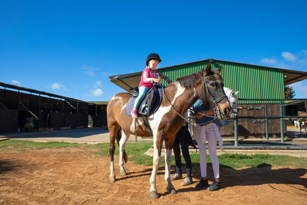 kislány a tanulás lovagolni a ló egy lovas iskolában - Fotó, kép